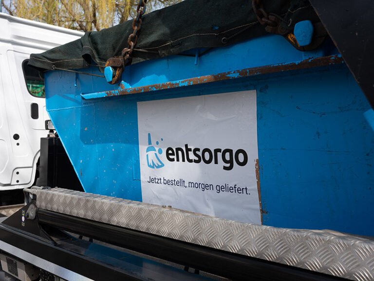 Nahaufnahme eines blauen Absetzcontainers mit Firmenlogo.