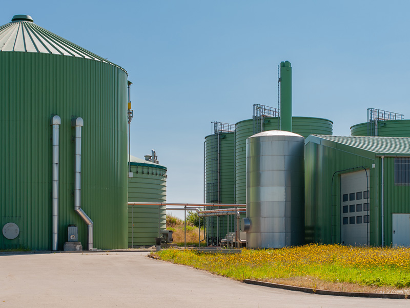 Blick auf eine Biogasanlage mit verschiedenen Türmen und Gebäuden.