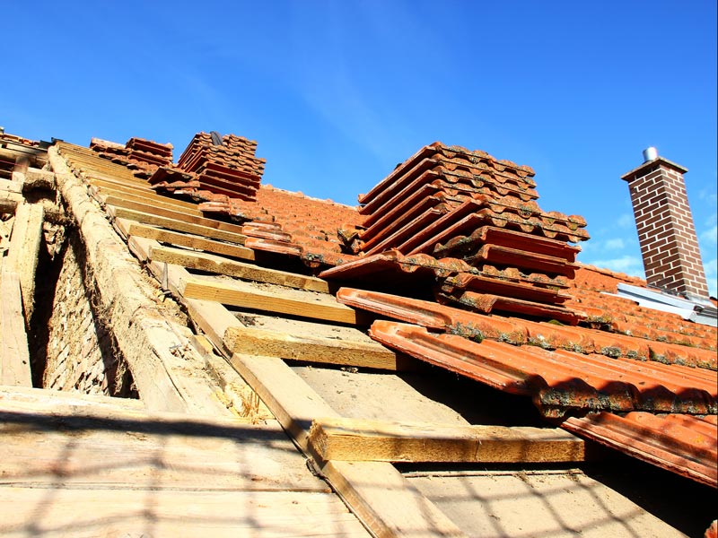 Ein Hausdach mit teilweise entfernten Dachziegeln.
