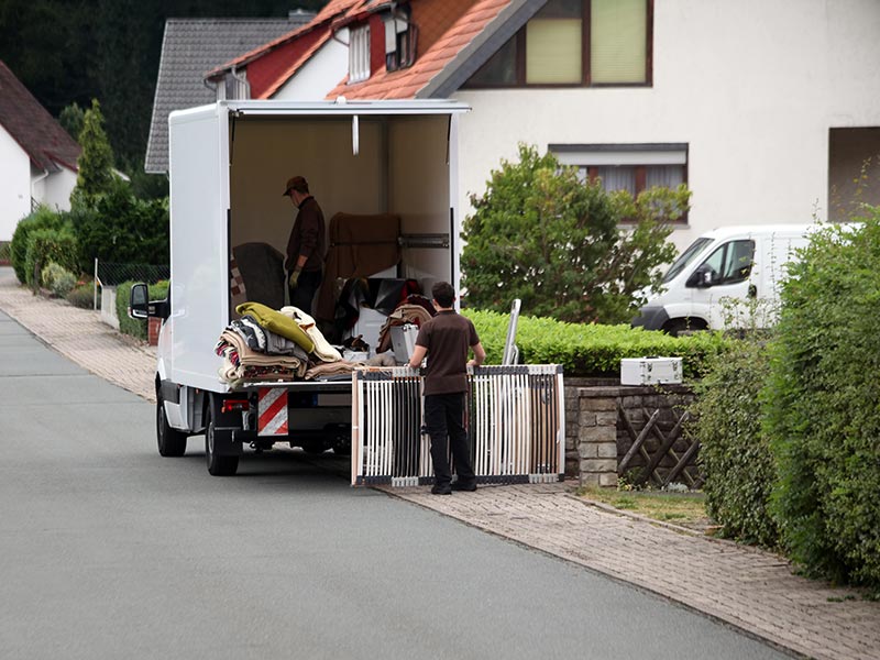 Professionelle Entrümpeler beladen einen LKW mit Hausrat.