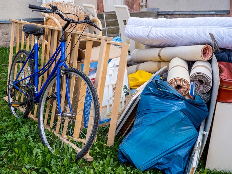 Fahrrad steht neben weiterem Sperrmüll auf einer Wiese.