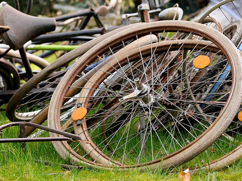Alte Laufräder, Mäntel und Reifen von Fahrrädern liegen auf einem Haufen.