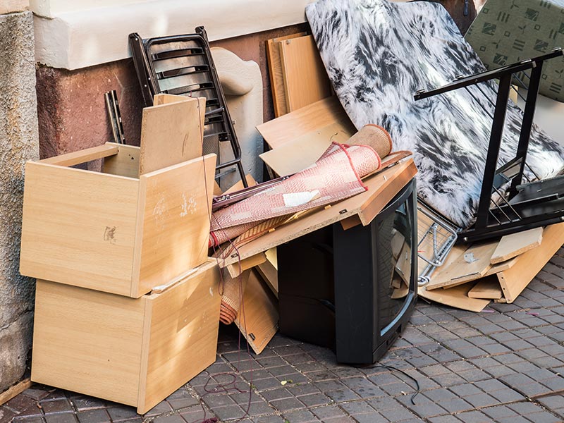 Alter Fernseher steht neben anderem Sperrmüll auf der Straße.