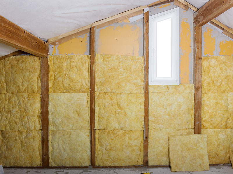 Glaswolle Blöcke zwischen Holzleisten an einer Wand.