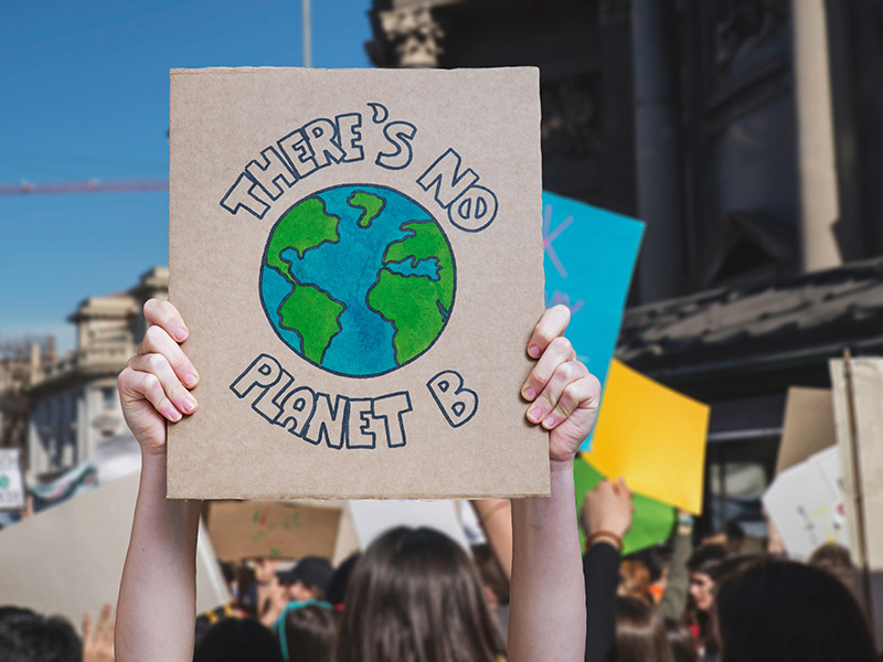 Person hält Protestschild auf Klimaschutz Demo hoch.