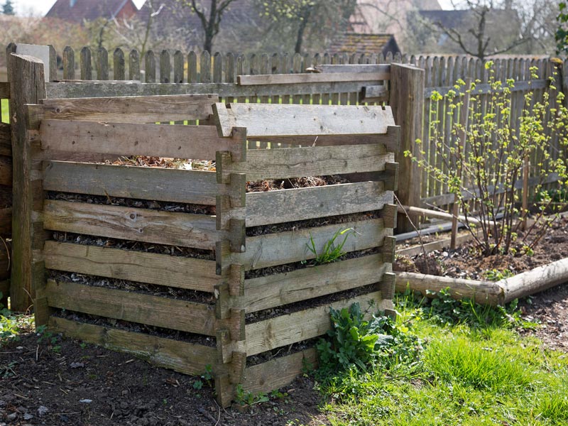 Kompost aus alten Holzleisten in einem Garten.