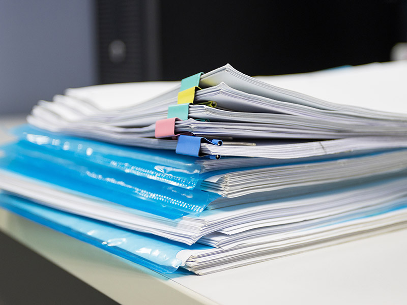 Dokumente und Unterlagen liegen in Plastikmappen auf einem Schreibtisch.