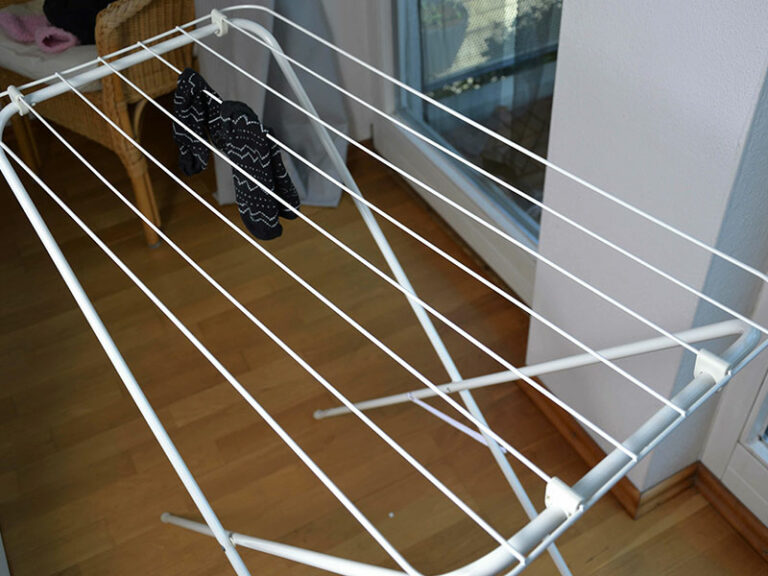 Ein leerer aufgebauter Wäscheständer steht in einer Wohnung.