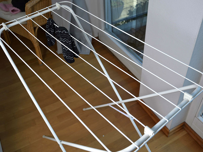 Ein leerer aufgebauter Wäscheständer steht in einer Wohnung.